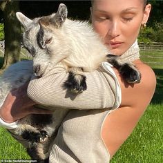 a woman holding a goat in her arms