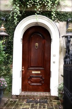 a wooden door is surrounded by greenery