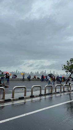 people walking down the street with umbrellas on a rainy day