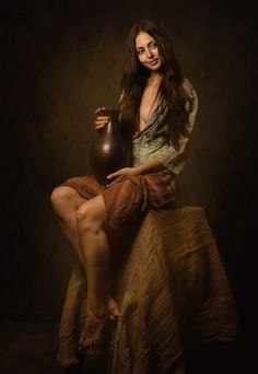 a woman sitting on top of a bed next to a brown vase in her hand