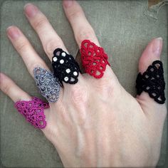 four different colored crocheted rings on someone's hand