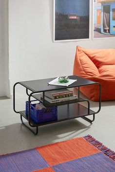 a living room with an orange couch and coffee table in the middle, next to a blue rug