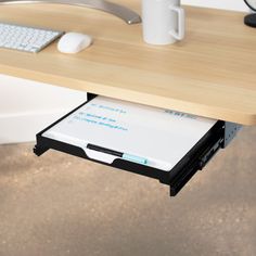 a computer desk with a keyboard and mouse on it's left side, attached to a drawer underneath the desk