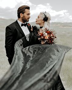 a man and woman dressed in black standing next to each other