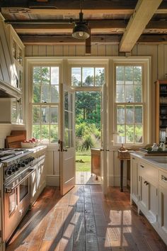 an open kitchen with wooden floors and white cabinets is shown in this image, the sun shines through the windows