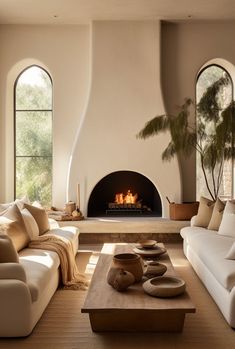 a living room filled with furniture and a fire place in the middle of a room