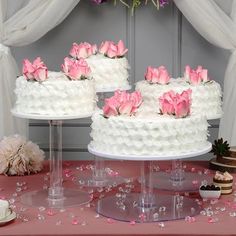 three tiered wedding cake with pink roses on top and white frosting, surrounded by confetti