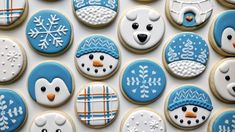 decorated cookies in the shape of snowmen and polar bears are arranged on a white surface