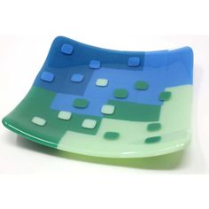 a blue and green glass plate sitting on top of a white table