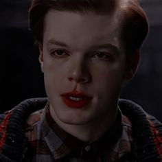 a close up of a person wearing a shirt and tie with red lipstick on his face