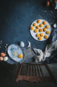 an overhead view of eggs and other food items on a blue table with a wooden chair