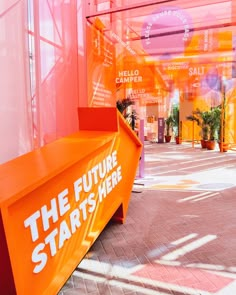 the future starts here sign is displayed in front of an orange structure with white lettering