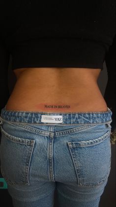 the back of a woman's stomach with a small tattoo on it