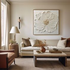 a living room filled with furniture and a large flower painting on the wall above it