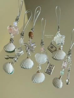 several seashells and charms hanging from hooks