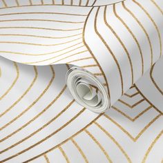 a white and gold wallpaper with metallic lines on the bottom half of it,