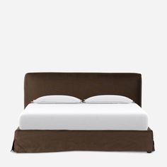 a bed with a brown headboard and white sheets on it's sides, against a gray background