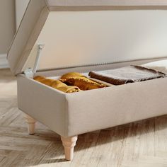 an open suitcase sitting on top of a hard wood floor next to a bed frame