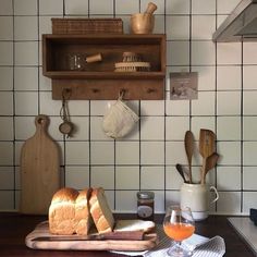 bread, butter and other kitchen items on a cutting board in front of a tiled wall