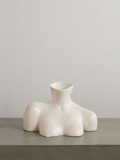 a white vase sitting on top of a table