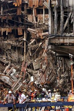 construction workers stand in front of the rubble