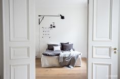 a bedroom with white walls and wooden floors