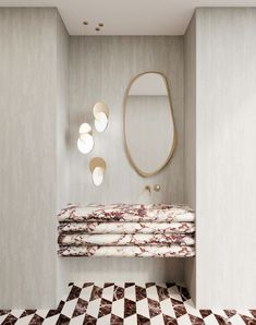 a bathroom with a checkered floor and marble counter top, along with an oval mirror on the wall