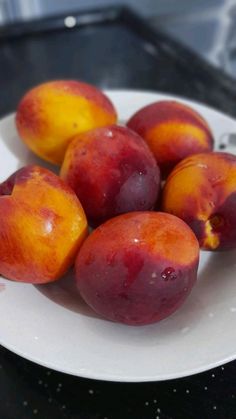 a white plate topped with peaches on top of a table