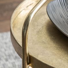 a close up of a metal table with a plate on it and a rug in the background