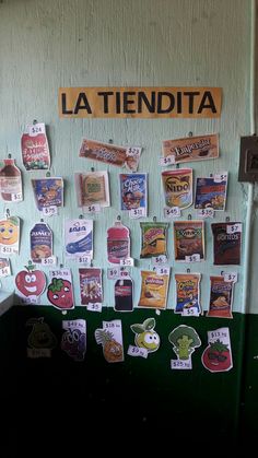 a bulletin board is covered with magnets and stickers that read la tendita