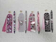 five hello kitty pens lined up next to each other with tassels on them