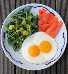 two eggs, spinach and avocado on a plate