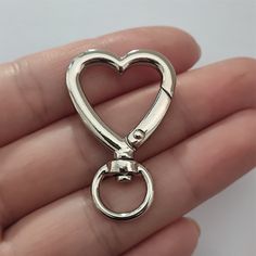 a heart shaped keychain is held in someone's hand