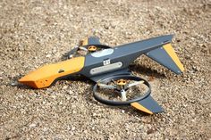 a remote controlled flying device laying on the ground with its wheels still attached to it