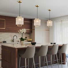 a modern kitchen with marble counter tops and bar stools