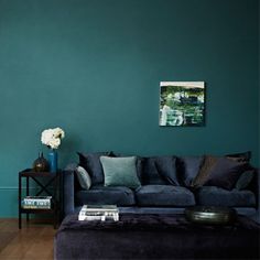 a living room with green walls and blue furniture