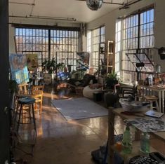 a living room filled with furniture and lots of windows next to a painting on the wall