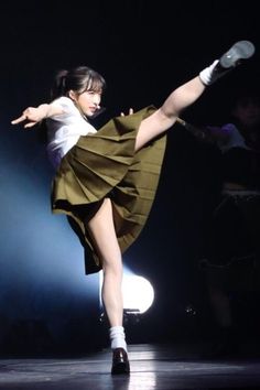 a woman is dancing on stage with her legs spread out