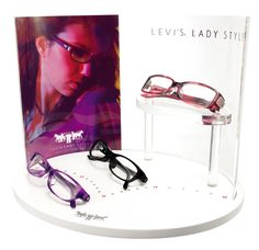 a pair of glasses sitting on top of a white table next to a magazine cover