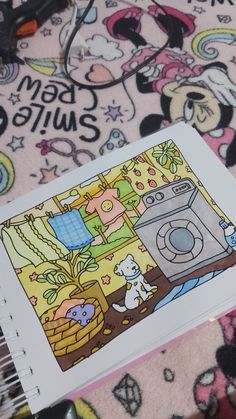 an open coloring book sitting on top of a bed covered in cartoon characters and toys