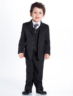 a little boy in a suit and tie standing up for the camera with his hands in his pockets