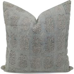 a gray pillow with embroidered leaves on the front and back, sitting on a white surface