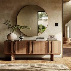 a large round mirror hanging on the wall above a wooden cabinet in a living room