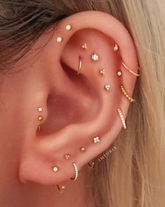 a woman wearing gold ear piercings with clear stones