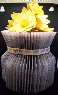 an origami flower pot with yellow flowers in it's center and words on the bottom