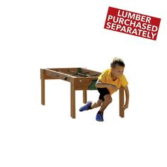 a young boy sitting on top of a wooden table next to a sign that says lumber purchased separately