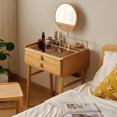 a bedroom with a bed, table and mirror on the wall next to a window