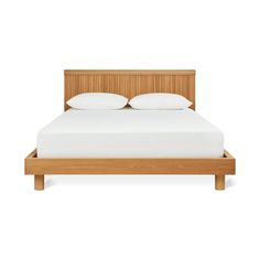 an image of a bed with white pillows and wooden headboard on the bottom side