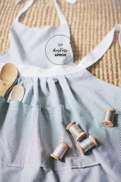 an apron and wooden spoons are on the bed next to a dress that says diy kitchen apron