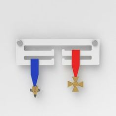 two medals are hanging on the wall with one gold and one red medal is placed next to each other